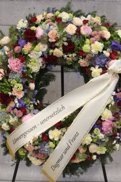 Trauerkranz mit bunten Blumen und Trauerschleife