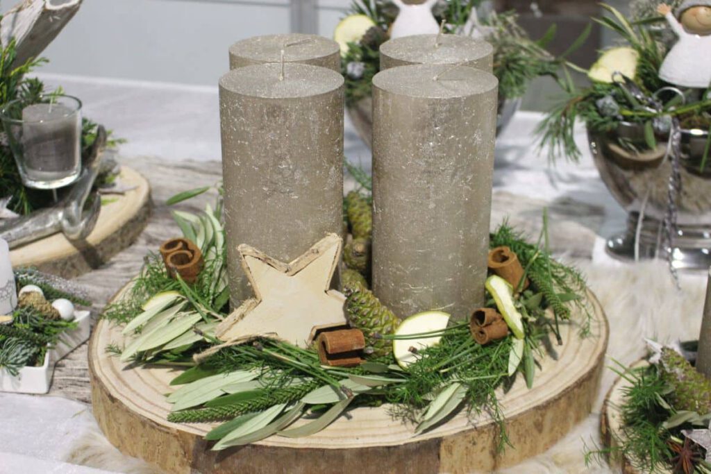Baumscheibe mit Grün und Weihnachtsdeko und grauen Kerzen