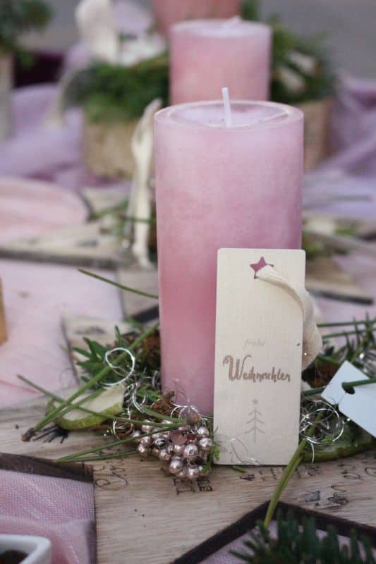 Holzstern mit rosa Kerze